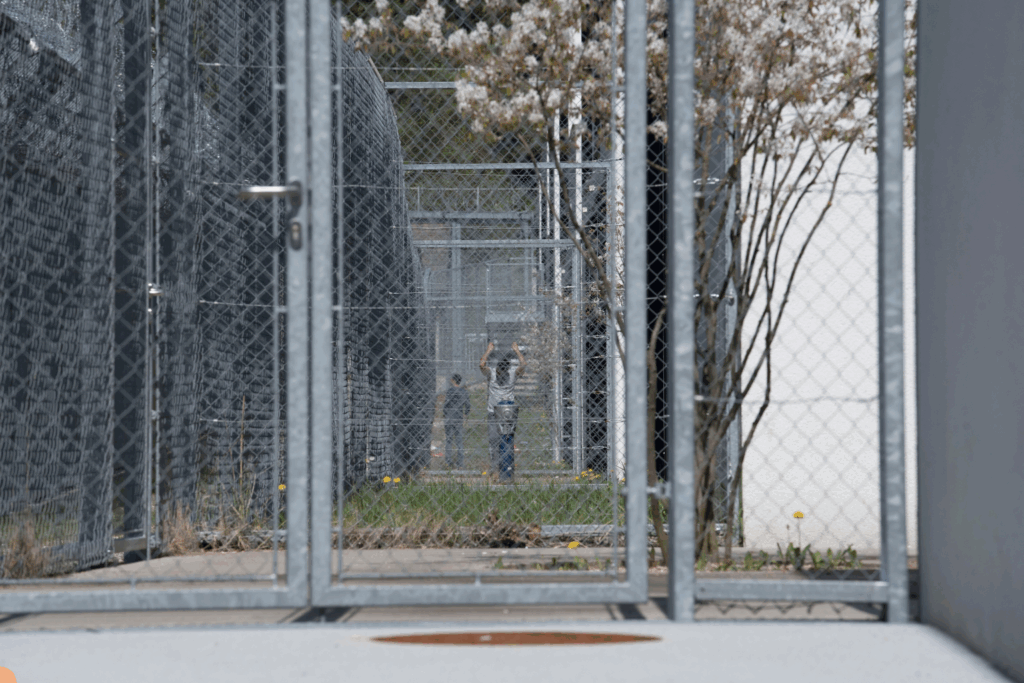 Cárcel de inmigración con rejas, mostrando un individuo en un área de detención, representando arrestos de ICE en Florida.